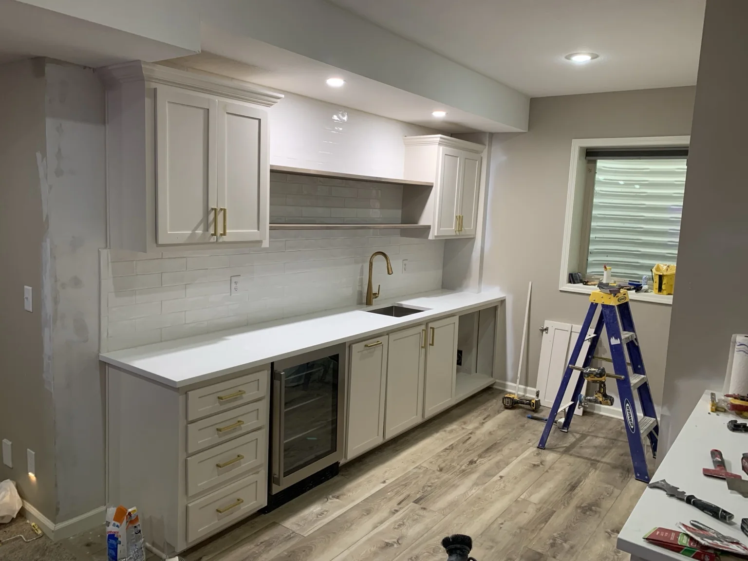 Custom white wet bar cabinetry and floating shelves completed by KC Handyman in Overland Park, Kansas